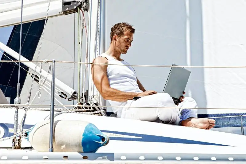 Laptop Entrepreneur Working on boat as digital nomad jobs